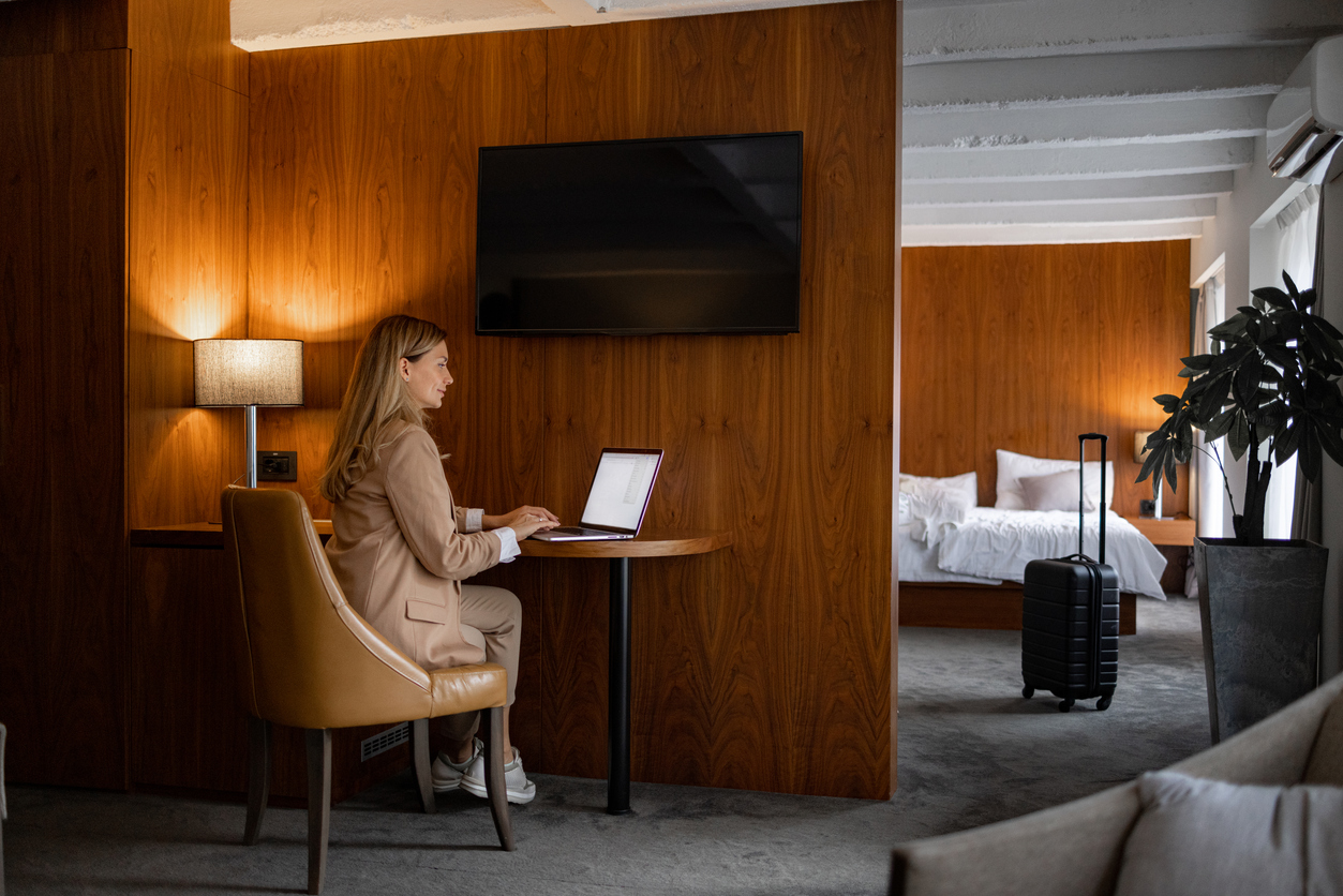 Woman on a business trip using laptop in the hotel room to work