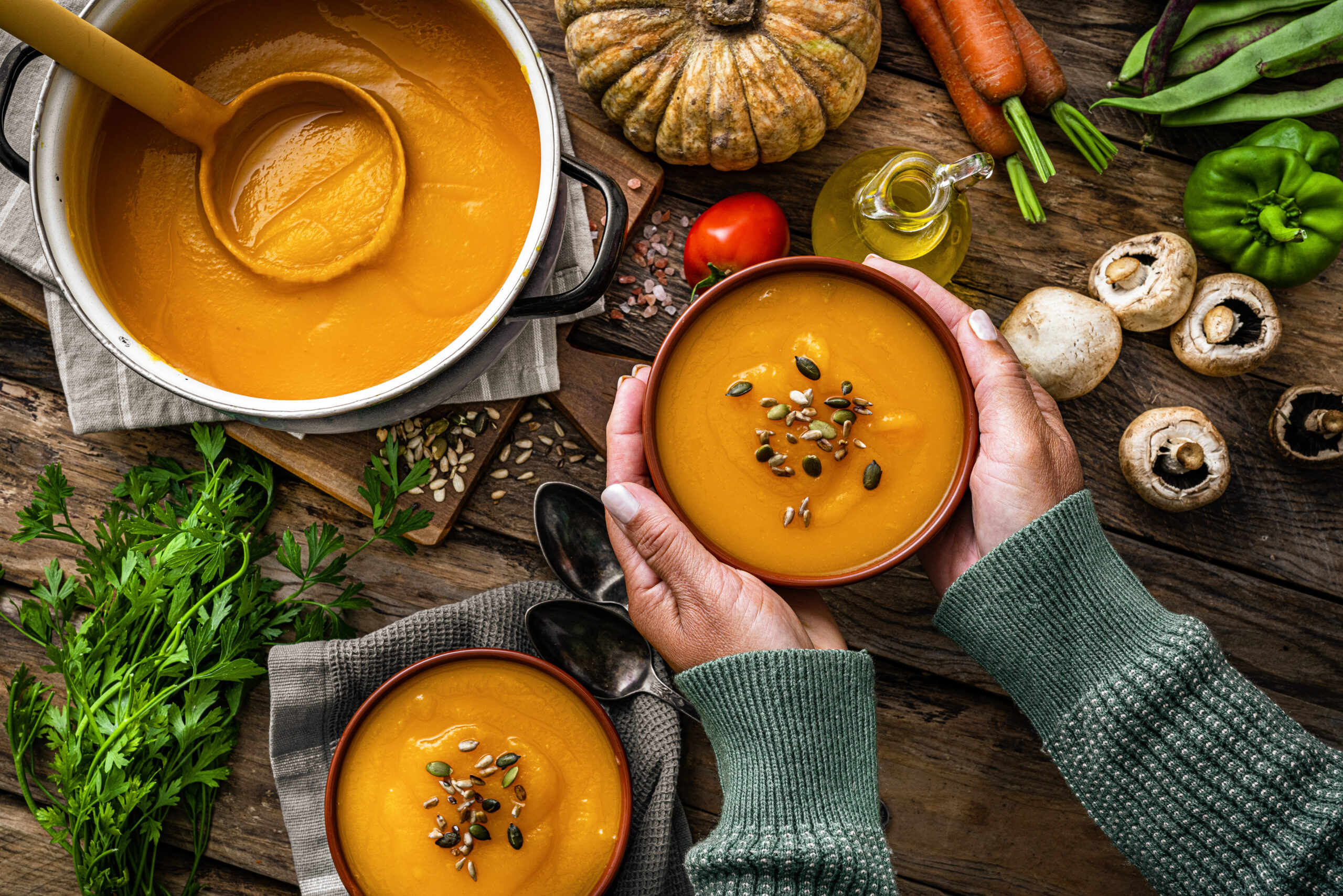 Woman holding a bowl of pumpkin soup for Thanksgiving meal