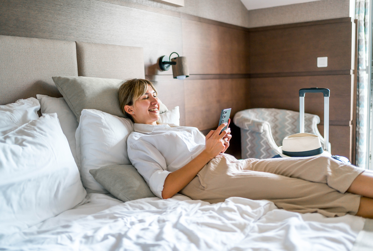 Woman using phone in a hotel room