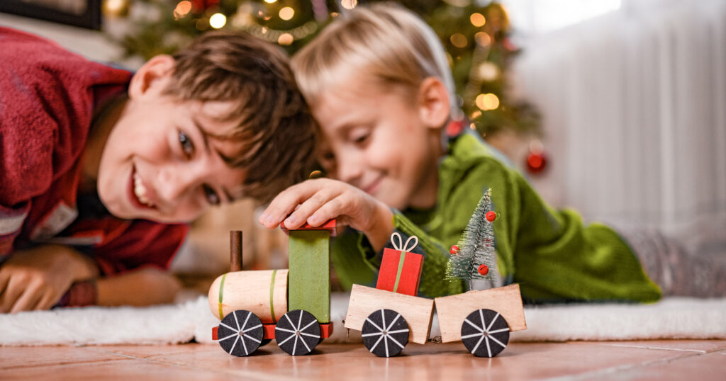 Two Brothers Playing with a Toy Wooden Train at Christmas