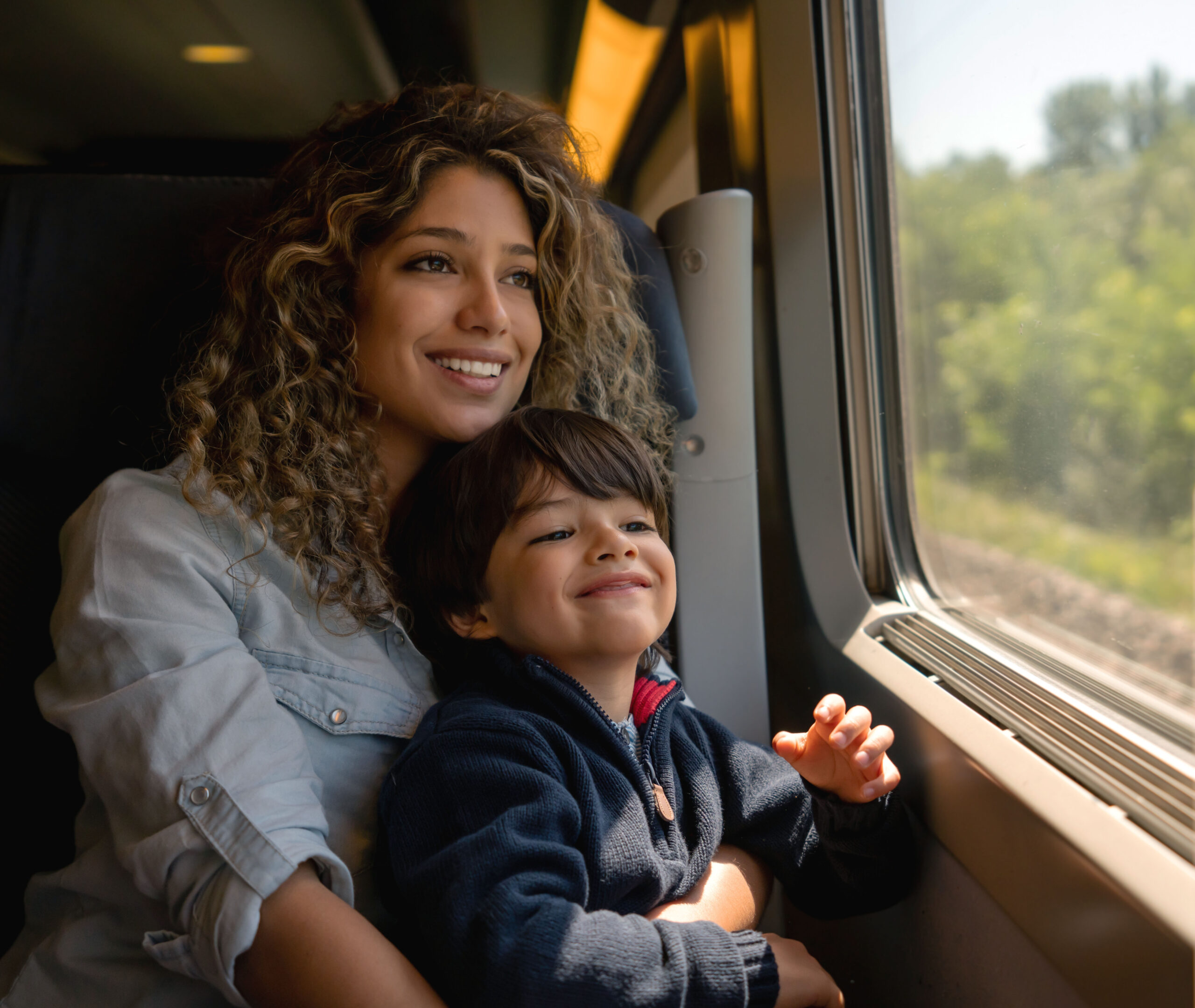 Happy mother and son riding on the train